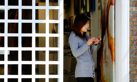 A woman uses her smartphone in Beijing. WeChat is being tipped as China's first smartphone app to be a big seller worldwide. Photograph: Nelson Ching/Bloomberg via Getty Images